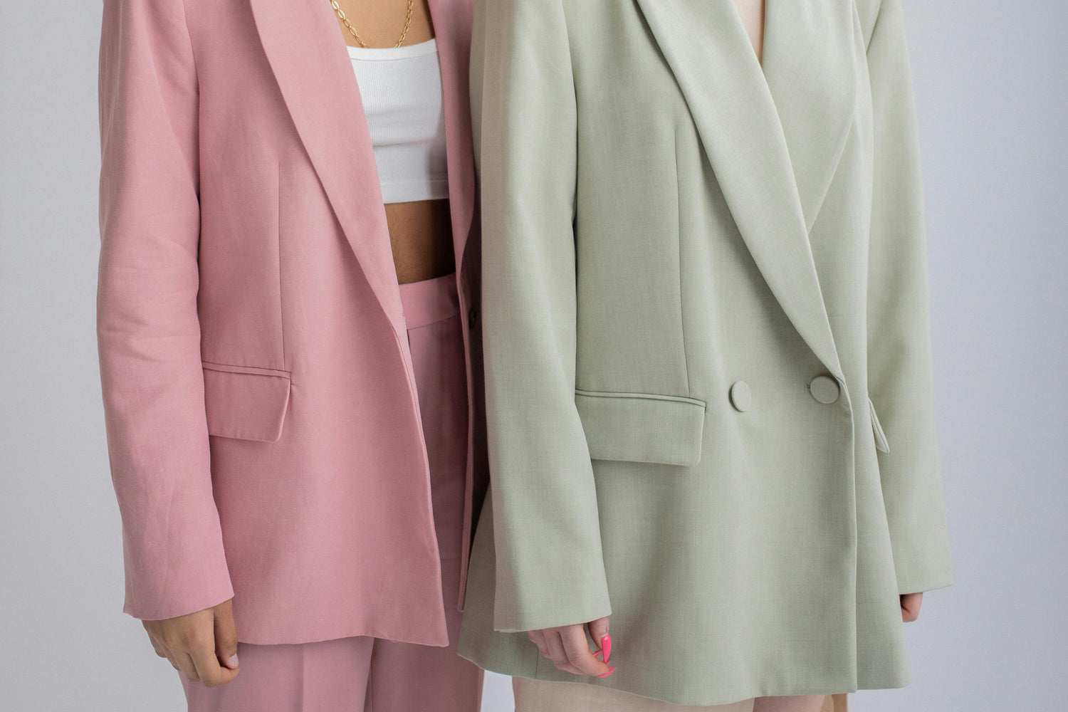 deux personnes debout portant un blazer rose et vert